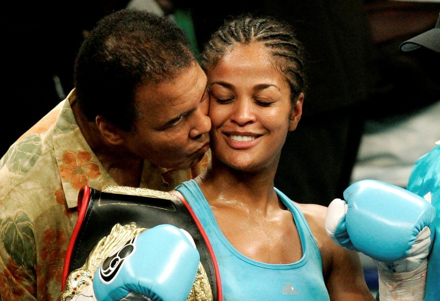 WBC and WIBA super middleweight champion Laila Ali is kissed by her father, boxing great Muhammad Ali, at the MCI Center in Washington in this June 11, 2005 file photo. REUTERS/Jason Reed/File Photo